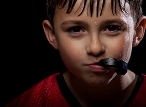 little kid holding athletic mouthguard with mouth